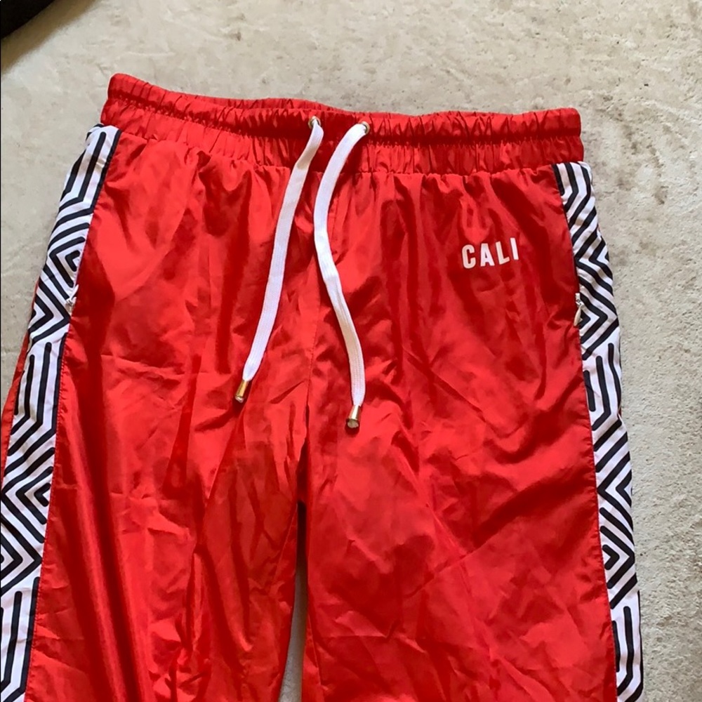Red windbreaker track pants